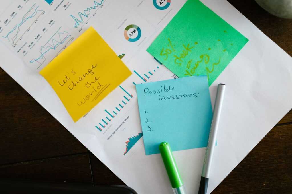 Startup brainstorming with charts, colorful sticky notes, and planning strategies for success.